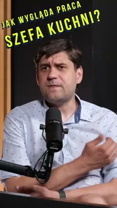 Rozmówca przed mikrofonem w pionowym kadrze.
